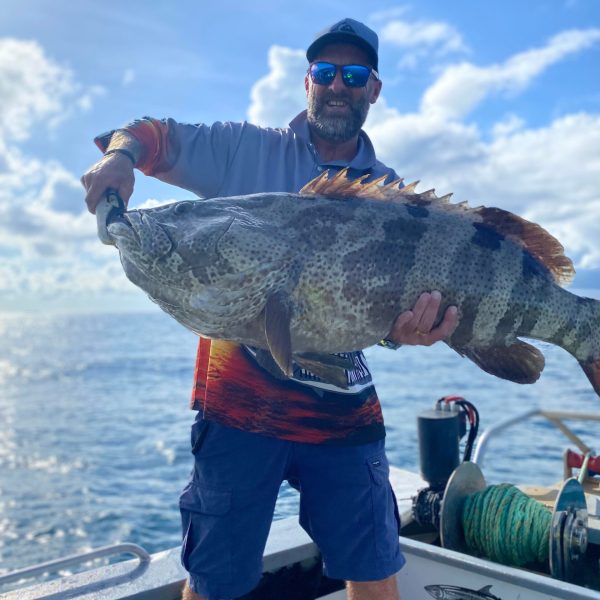 a man holding a fish in the water