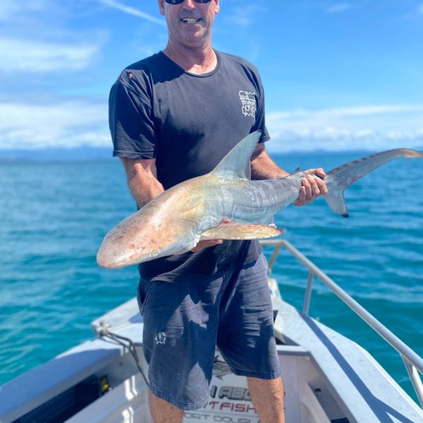 a man holding a fish in the water