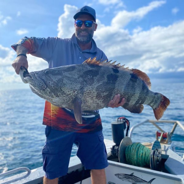 a man holding a fish in the water