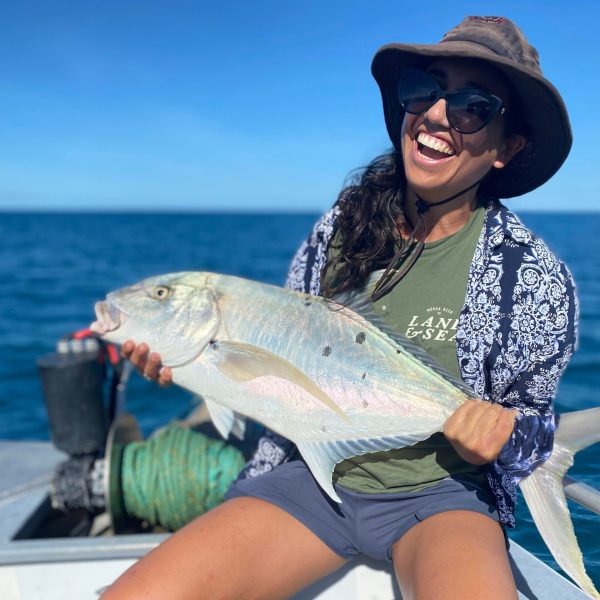 a woman sitting on a fish in the water