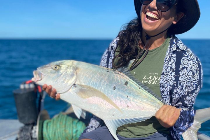 a woman sitting on a fish in the water