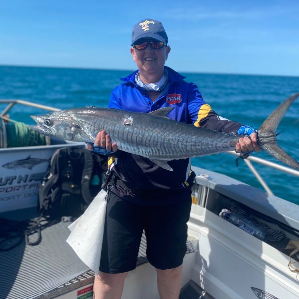 a man holding a fish on a boat
