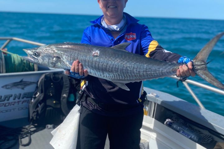 a man holding a fish on a boat