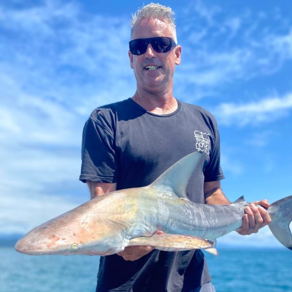 a man holding a fish in the water
