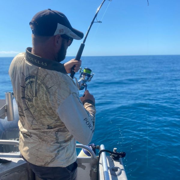 a man standing next to a body of water
