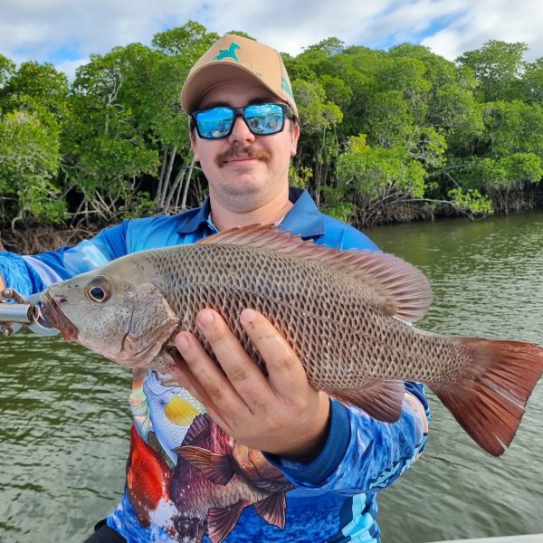 a person holding a fish swimming under water